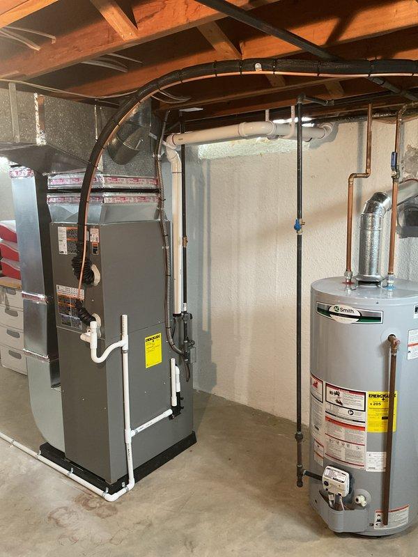Completed full HVAC system installation including a 70,000 BTU gas furnace in the basement mechanical room and a 2.5-ton air conditioning condenser unit positioned on a concrete pad in the rear yard. Installed all necessary refrigerant line sets connecting the outdoor condenser to the indoor air handler, routed black flexible ductwork from furnace to existing distribution system, and connected white PVC condensate drainage piping. Mounted electrical disconnect box on perimeter fence adjacent to condenser unit, established all electrical connections, and reconnected gas supply line to furnace with proper shut-off valve. Completed all mechanical permits as required, performed system startup procedures, verified proper airflow and refrigerant charge levels, and confirmed all safety controls and thermostatic operations functioning within manufacturer specifications.
