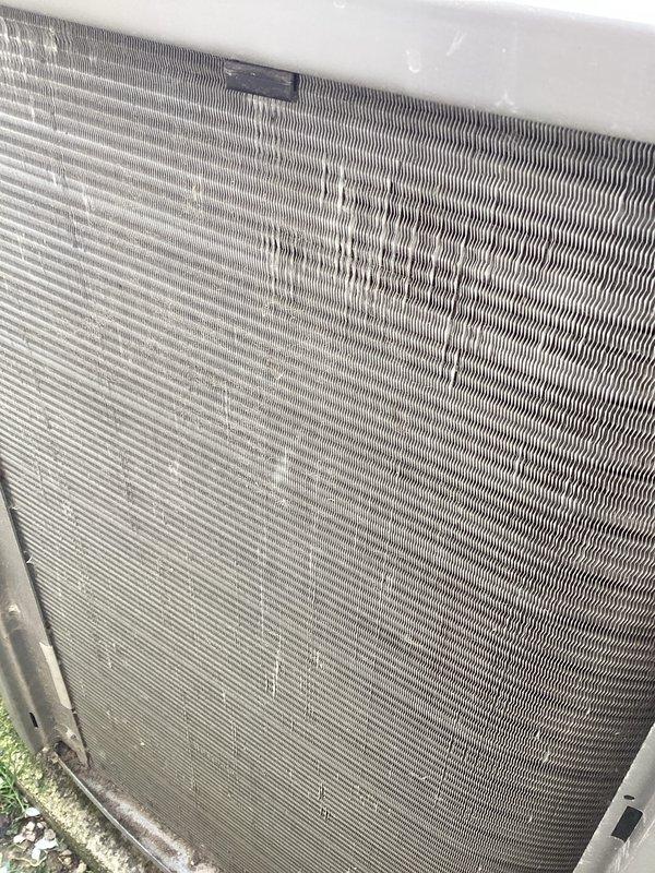 Completed routine air conditioning maintenance on residential outdoor condenser unit. Inspected condenser coil and noted moderate dust and debris accumulation on fins throughout the assembly. Documented unit condition with photos showing weathered cabinet exterior and dirt buildup on heat exchanger surfaces. All components appeared intact with no visible damage to coil fins or cabinet structure. Unit operational and positioned properly on concrete pad with adequate clearance for airflow.