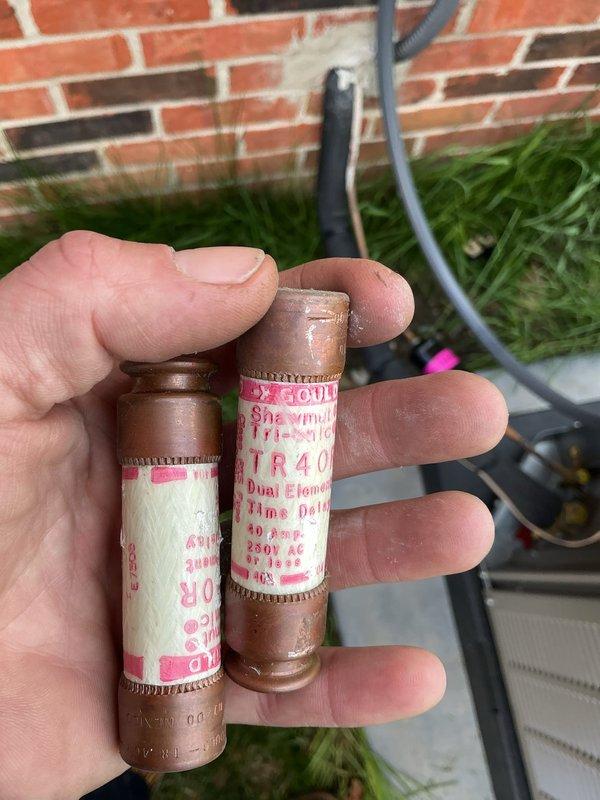 Responded to no-cooling call on 2-month-old system experiencing failure on first cooling call since installation. Upon arrival, verified thermostat calling for cooling and checked electrical panel breakers in on position with no power to outdoor unit. Inspected disconnect box at condensing unit and discovered two blown TR40 time-delay fuses. Replaced both failed fuses, restored power to system, and verified proper operation of condensing unit with compressor and condenser fan running normally. System now cooling properly with all components functioning as designed under warranty coverage.