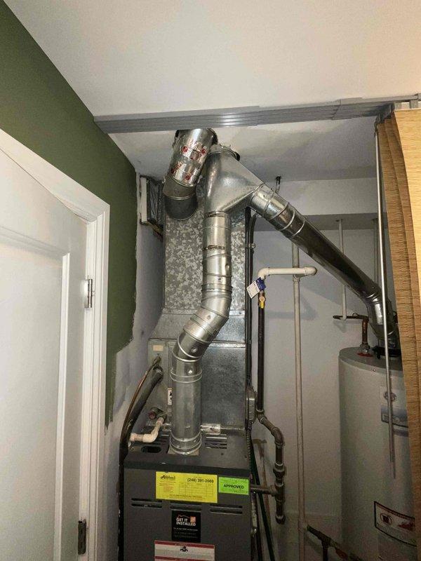 Provided estimate for complete HVAC system replacement in condominium utility room, including 2013 furnace and 1998 air conditioning system under BOGO promotion. Assessed existing equipment configuration with dual outdoor condenser units positioned on concrete pads and indoor furnace with water heater in compact mechanical space. Documented current system layout and specifications to prepare comprehensive replacement proposal for aging cooling system while existing furnace remains operational.