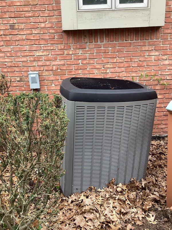 Responded to service call for outdoor condenser unit reported to be leaning. Upon arrival, inspected 2019 air conditioning system positioned against brick wall exterior. Confirmed unit was not level and assessed surrounding ground conditions, noting settled earth and debris accumulation around base. Documented equipment condition with photographs showing condenser placement, ground settlement, and proximity to building structure. Unit remains under parts warranty. Provided customer with findings and recommendations for proper leveling to prevent refrigerant line stress and potential compressor damage.