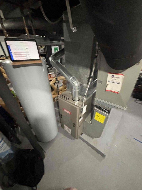 Conducted comprehensive site evaluation for full HVAC system replacement in residential basement installation. Assessed existing gray metal furnace/air handler unit with connected ductwork, water heater, and current AC system configuration to provide accurate equipment sizing and installation requirements. Documented existing equipment conditions, spatial constraints, ductwork connections, and utility access points through detailed photography to develop complete replacement system proposal for customer seeking installation within the next couple weeks.