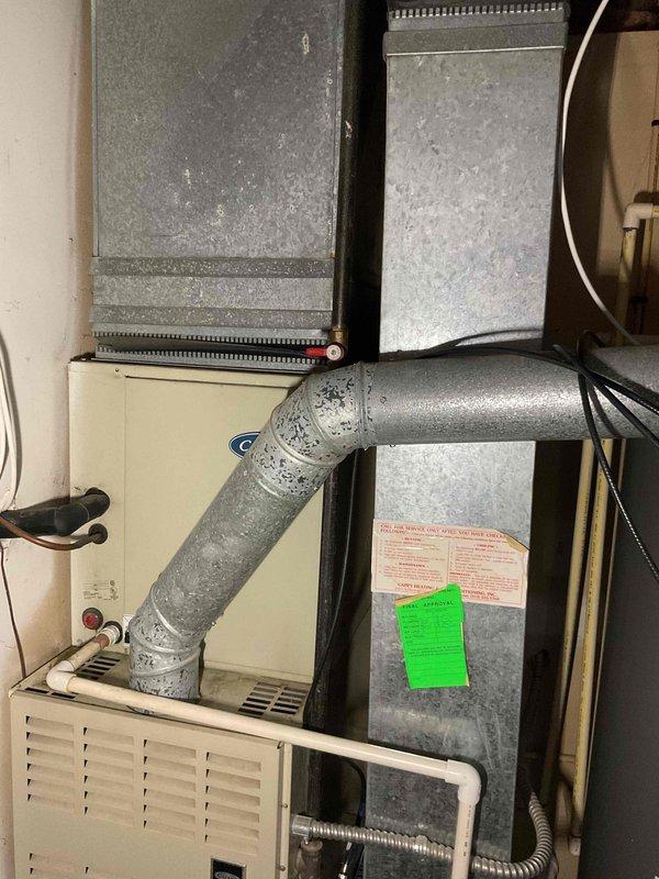 Conducted comprehensive assessment of existing residential HVAC system located in basement utility area for full system replacement estimate. Evaluated current furnace unit with flexible ductwork connections, air handler configuration, and overall mechanical room layout to determine equipment specifications and installation requirements. Documented existing system components including furnace, ductwork with visible condensation on flex piping, and spatial constraints to provide accurate recommendations for complete HVAC system replacement including new air conditioning unit and furnace installation.