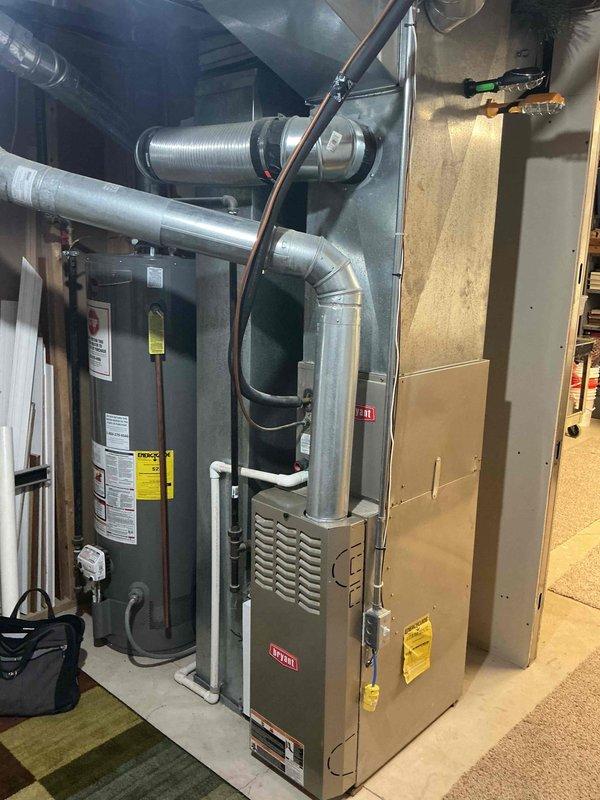 Conducted comprehensive assessment of 20+ year old natural gas furnace and air conditioning system located in basement mechanical room. Evaluated existing equipment condition, documented current installation configuration including ductwork connections and ventilation system, and provided detailed replacement estimate for both heating and cooling units. Current system operational at time of inspection.