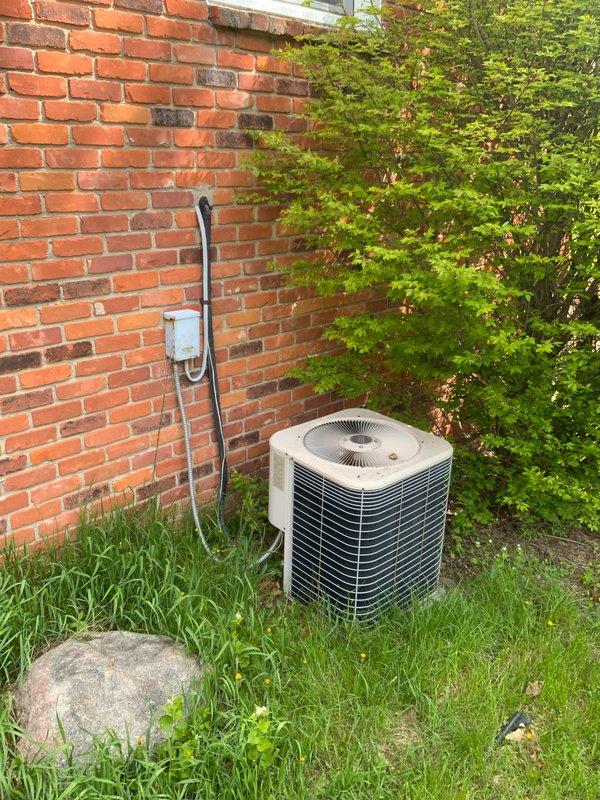 Conducted on-site evaluation for complete HVAC system replacement at residential property with 16-year-old equipment. Assessed non-operational air conditioning condenser unit located on exterior pad adjacent to brick foundation and 90% efficiency natural gas furnace in basement. Documented existing equipment configuration, electrical service connections, and installation requirements for proposed replacement system.