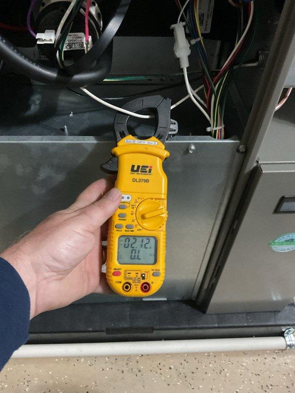 Completed annual cooling maintenance on residential split system. Unit exterior was heavily clogged with debris, dust, and fibrous material restricting airflow through condenser coils. Cleaned condenser coil and housing thoroughly to restore proper ventilation and heat exchange efficiency. Performed electrical diagnostics using digital multimeter, verifying system voltage and amperage readings within manufacturer specifications at 82.12 reading. Inspected all electrical connections and wiring harness inside unit compartment. System operational and running efficiently after cleaning and testing procedures completed.
