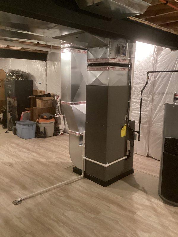 Completed full HVAC system installation including a 70,000 BTU furnace and 2.5-ton air conditioning unit in basement location with left-side configuration. Installed outdoor condenser unit on concrete pad adjacent to building exterior with copper refrigerant lines wrapped in foam insulation and PVC condensate drain line routed along brick wall. Reconnected all electrical connections and completed mechanical hookups per specifications. Requested and coordinated mechanical and electrical permits for the installation. Set up utility rebate processing documentation for DTE and SEMCO Energy programs.