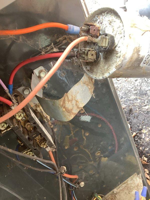 Completed scheduled air conditioning maintenance on outdoor condensing unit. Upon inspection, discovered heavily corroded dual-run capacitor with severe rust damage to terminals and extensive mineral buildup on casing, indicating electrical component failure due to moisture exposure. Replaced failed capacitor with new unit. Removed debris, twigs, and organic material from equipment compartment that had accumulated from outdoor exposure. Cleaned electrical connections and terminal points. Inspected wiring and conduit for damage. Unit tested and operational following component replacement and cleaning.