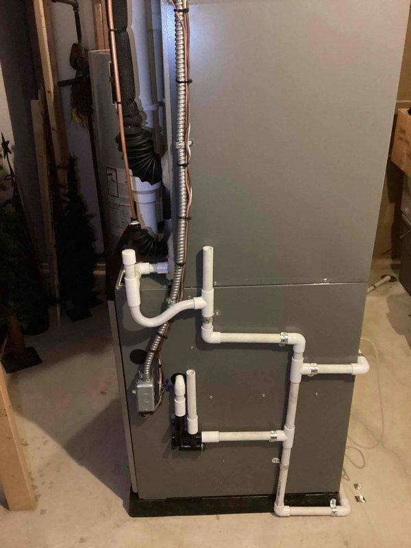 Completed full HVAC system installation including a 90,000 BTU furnace and 3.5-ton air conditioning unit. The furnace was installed in the basement utility area with proper PVC condensate drainage system, venting, and electrical connections, while the Lennox condenser unit was positioned on a pad against the exterior brick wall with refrigerant line set and disconnect box properly mounted. All mechanical and electrical permits were obtained, system was reconnected and tested for proper operation, and utility rebate documentation was processed.
