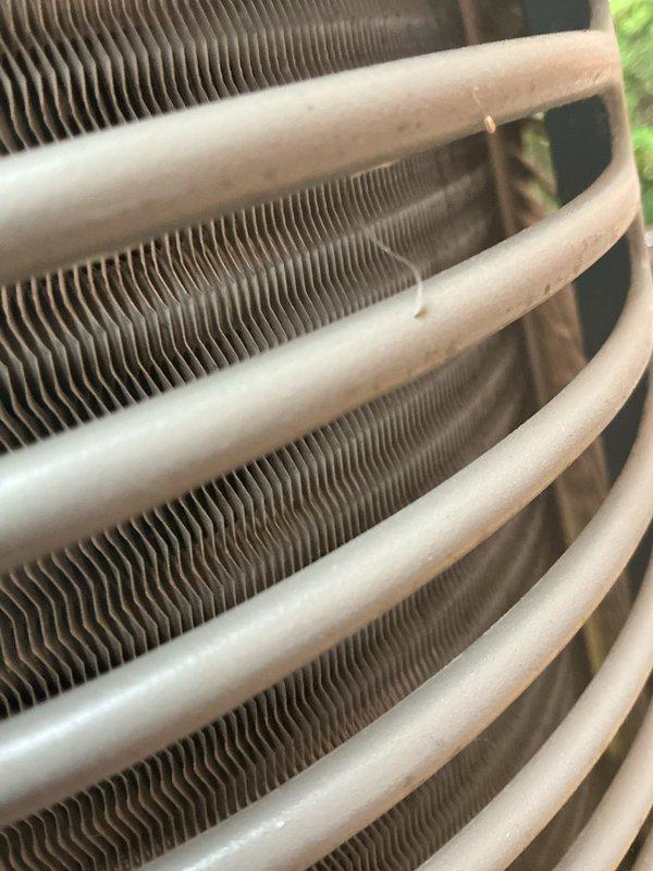 Completed comprehensive AC tune-up on 10-year-old system. Performed full maintenance inspection including evaluation of condenser coil and heat exchanger fins, verified proper operation of all components, and documented system condition with photographs. Unit operating within normal parameters with clean coil surfaces and intact protective grille assembly.