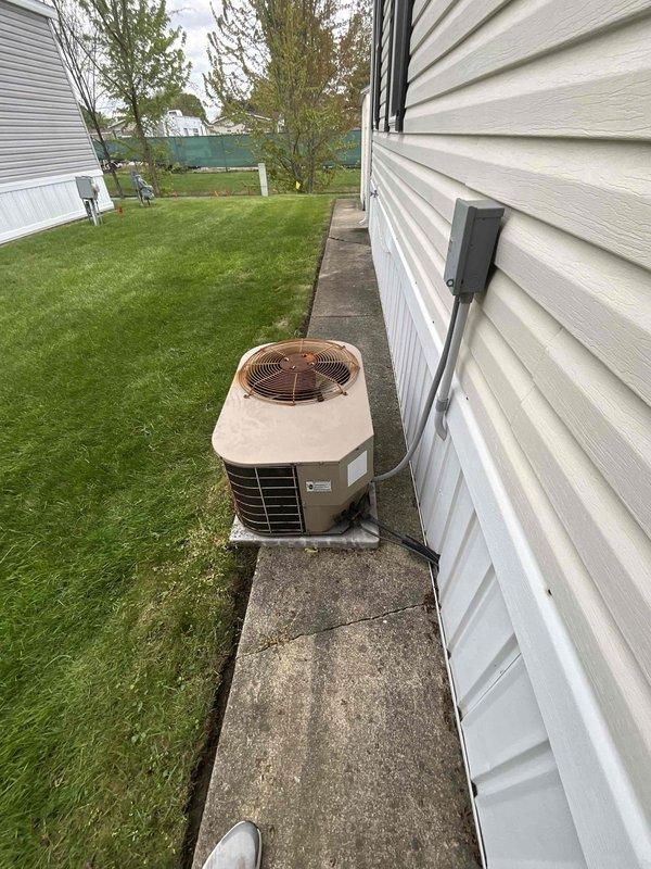 Provided comprehensive estimate for complete HVAC system replacement for small to mid-sized residential property (0-1200 sq ft) requiring heating and cooling capabilities with natural gas or propane energy source. Assessed existing outdoor condensing unit positioned on concrete pad in side-yard location between structures, evaluating current installation including refrigerant lines, electrical conduit, and drainage connections. Documented equipment configuration and site conditions to develop accurate proposal for new system installation.