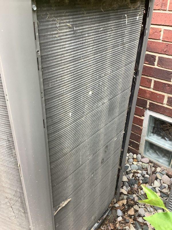 Completed annual cooling maintenance on residential air conditioning system. Inspected outdoor condenser unit, noting weathering and organic buildup on coil fins; cleaned exterior surfaces to restore proper airflow. Replaced dirty air filter with new unit, as evidenced by significant dust and debris accumulation on old filter. Verified system operation and documented equipment condition through photographic records.