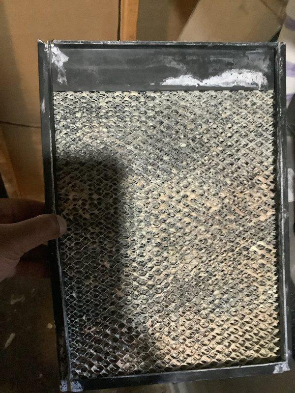 Completed seasonal air conditioning maintenance and tune-up on residential AC system. Performed comprehensive system inspection, checked refrigerant levels, cleaned condenser coils, and tested all electrical components. Inspected and documented condition of air filter showing significant dust and mineral deposit accumulation; filter displayed visible discoloration on honeycomb mesh pattern with white residue buildup along frame edges. System operational and ready for cooling season.