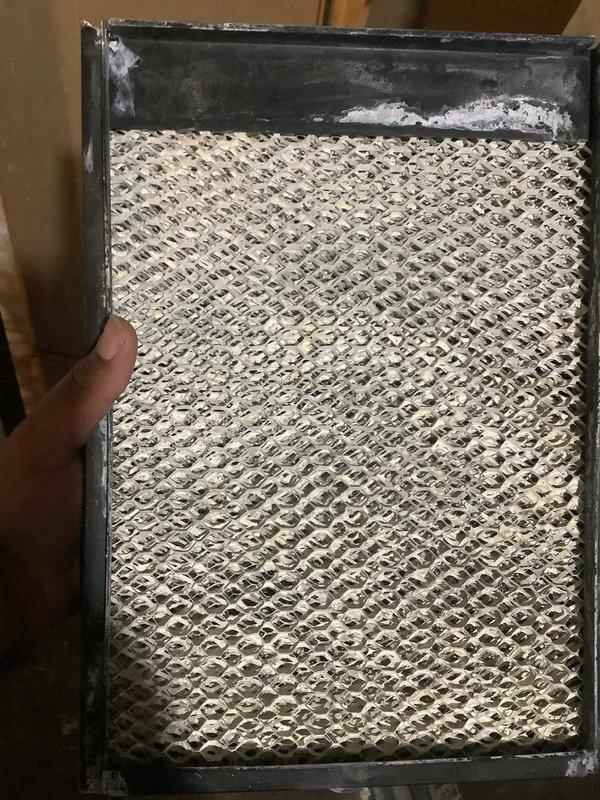 Completed seasonal air conditioning maintenance and tune-up on residential AC system. Performed comprehensive system inspection, checked refrigerant levels, cleaned condenser coils, and tested all electrical components. Inspected and documented condition of air filter showing significant dust and mineral deposit accumulation; filter displayed visible discoloration on honeycomb mesh pattern with white residue buildup along frame edges. System operational and ready for cooling season.