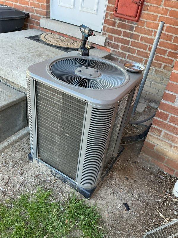 Completed scheduled maintenance on residential outdoor air conditioning condenser unit. Performed standard ACM (air conditioning maintenance) protocol including inspection of fan assembly, louvers, and exterior housing. Unit operational and positioned properly on concrete pad with refrigerant lines secured.