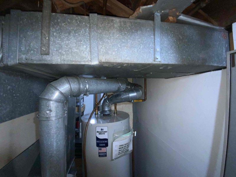 Provided estimate for replacement of 28-year-old natural gas furnace and air conditioning system located in basement. Current equipment operational but nearing end of service life with previous flame-out issue documented in May. Assessed existing installation configuration including ductwork connections, gas lines, and clearances to water heater for proper replacement specifications.