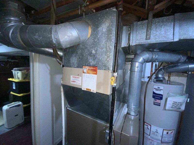 Provided estimate for replacement of 28-year-old natural gas furnace and air conditioning system located in basement. Current equipment operational but nearing end of service life with previous flame-out issue documented in May. Assessed existing installation configuration including ductwork connections, gas lines, and clearances to water heater for proper replacement specifications.