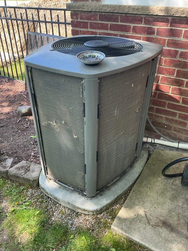 Completed annual cooling maintenance on outdoor condensing unit. Performed comprehensive inspection of residential air conditioning system including visual assessment of cabinet condition, grille integrity, and unit placement on concrete pad. Verified proper clearances around equipment and checked for any visible damage or deterioration to exterior components. Inspected condenser coils through protective mesh grilles and assessed overall system accessibility for service. Documented current equipment condition showing normal weathering consistent with outdoor installation. Unit operational with no immediate service concerns identified during maintenance visit.