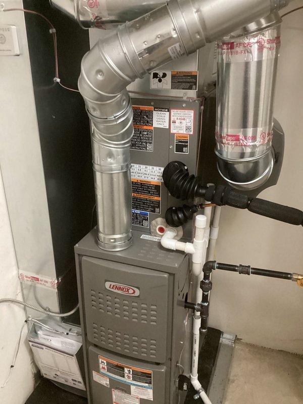 Completed full HVAC system installation including a Lennox 70,000 BTU furnace, 2-ton air conditioning unit with rear discharge configuration, and whole-home humidifier. Installed new metallic ductwork with proper sealing at all joints, routed PVC condensate drain lines, and made all necessary electrical connections. System positioned in utility closet with louvered door for proper ventilation, all components labeled per code requirements, and mechanical and electrical permits obtained prior to installation.