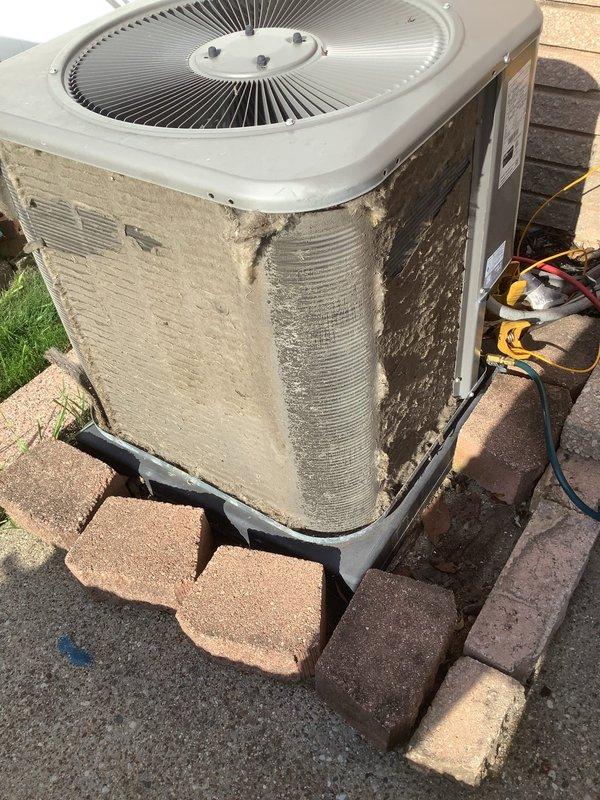 Completed annual cooling maintenance on residential split system air conditioning unit. Upon arrival, observed heavy accumulation of dirt, dust, and grime on condenser exterior panels and coils. Performed comprehensive inspection of outdoor condenser unit including fan motor operation, refrigerant line connections, and electrical components. Cleaned condenser coils and exterior surfaces, removing significant debris buildup that was restricting airflow and reducing system efficiency. Verified proper fan operation and checked refrigerant line insulation integrity. System operational and running within normal parameters upon completion of maintenance service.