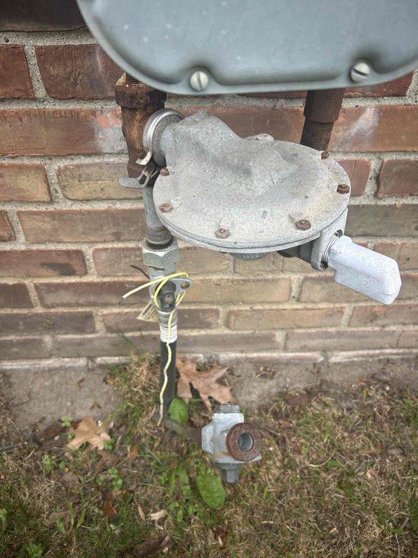 Performed site evaluation for new tankless water heater installation with natural draft venting configuration. Assessed existing gas meter infrastructure and utility connections on exterior brick wall to determine compatibility and capacity requirements for tankless unit upgrade. Documented current gas supply system condition and specifications to prepare comprehensive estimate for complete tankless water heater installation.