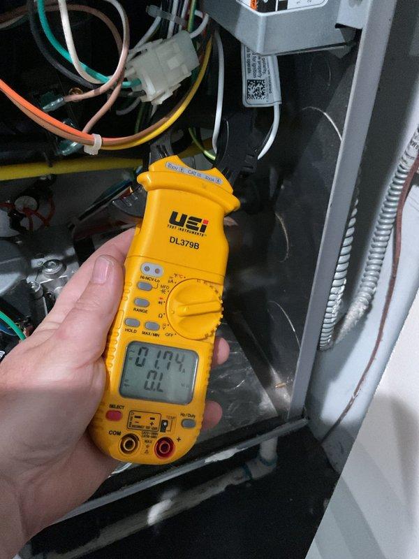Completed annual cooling maintenance on residential air conditioning system. Performed electrical diagnostics on indoor air handler using digital multimeter to verify proper voltage and amperage readings across control circuits and components. Inspected outdoor condenser unit, noting dirt and debris accumulation on coil fins and wire guard assembly. Unit operational at time of service with all electrical parameters within normal operating range. Documented system condition with photographs for maintenance records.