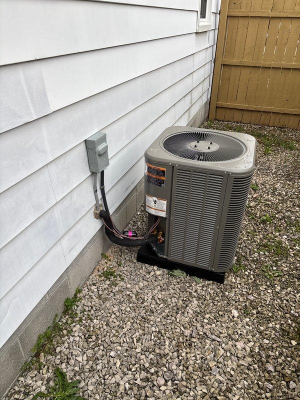 Completed installation of Energy Star certified wall-mounted tankless water heater in interior utility closet with new electrical circuit and dedicated disconnect. Installed white PVC venting system through exterior wall, connected gas supply lines, and integrated expansion tank with black piping configuration. Simultaneously installed outdoor air conditioning condenser unit on gravel pad with proper refrigerant line connections, electrical disconnect box mounted to exterior siding, and conduit run through vinyl siding. All mechanical and electrical permits obtained prior to installation, system tested and verified operational upon completion.