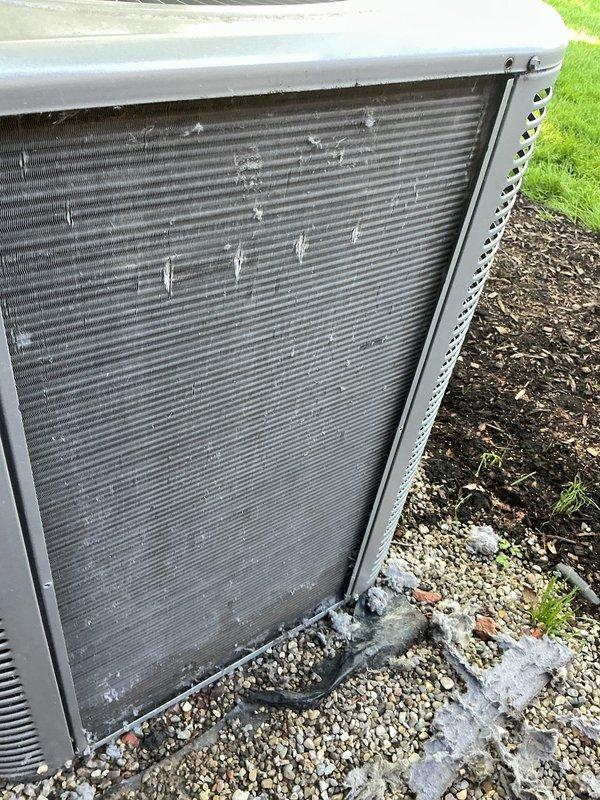 Returned to complete scheduled ACM (air conditioning maintenance) that could not be finished during previous visit. Performed thorough inspection and cleaning of outdoor condenser unit, which showed heavy accumulation of cottonwood seeds, lint, and debris throughout the coil fins. Cleaned heat exchanger coils to remove fibrous buildup that was restricting airflow and reducing system efficiency. Unit restored to proper operating condition with improved airflow through condenser coils.