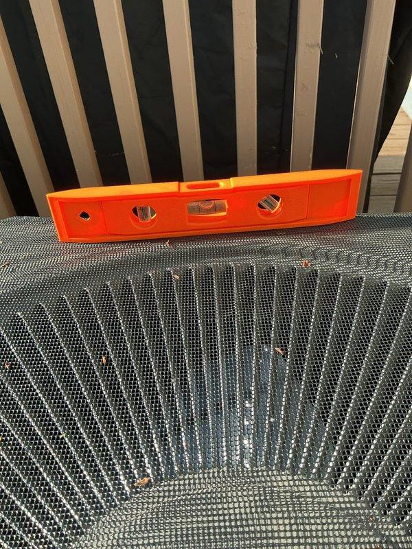 Responded to service callback regarding unlevel air conditioning unit following recent installation of 70,000 BTU furnace and 2-ton rear-discharge AC system. Verified unit levelness using precision spirit level on top of condenser cabinet and documented measurements with photographs. Made necessary adjustments to ensure proper equipment leveling for optimal operation and drainage.