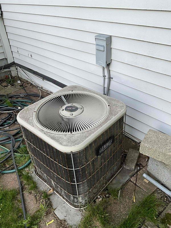 Conducted comprehensive equipment evaluation and replacement estimate for 30-year-old natural gas furnace and air conditioning system located in main utility room. Assessed existing Lennox outdoor condenser unit on concrete pad with exterior electrical disconnect, documented electrical panel configuration showing dual-row breaker arrangement with main disconnect, and evaluated current operational status of aging HVAC equipment to provide complete system replacement recommendations.