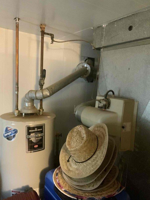 Conducted full system estimate for replacement of 30-year-old air conditioning system requiring immediate replacement. Assessed existing outdoor condensing unit with cylindrical configuration and evaluated indoor utility area housing water heater and associated mechanical components including ductwork and auxiliary equipment. Documented current system configuration, electrical connections, and installation conditions to provide comprehensive quote for new AC system replacement.
