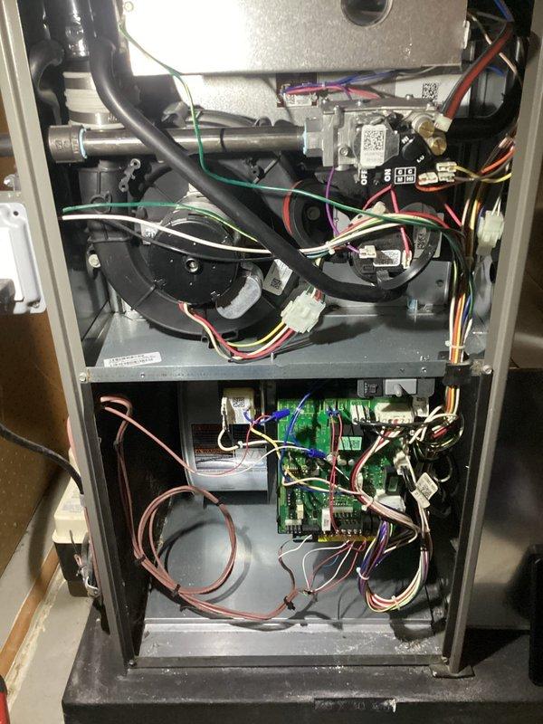 Completed comprehensive ComfortGuard maintenance inspection on residential HVAC furnace system. Removed access panels to perform thorough internal examination of all mechanical and electrical components including blower motor assembly, gas valve piping, control board connections, and wiring harnesses. Verified proper operation of green circuit board with all wire terminals and connectors secure. Inspected condition of flexible hoses, metallic piping, and multi-colored wire bundles throughout upper and lower compartments. All components found in good working order with no immediate service needs identified. System operating within normal parameters.