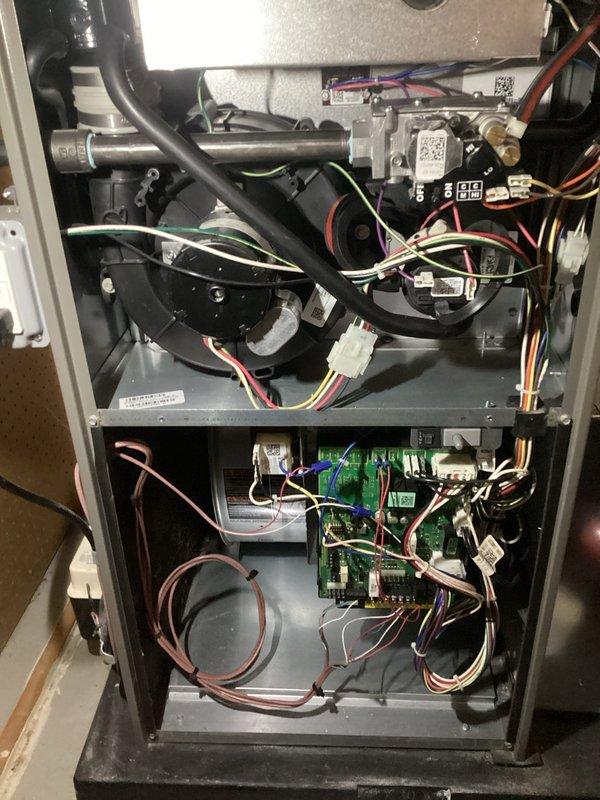 Completed comprehensive ComfortGuard maintenance inspection on residential HVAC furnace system. Removed access panels to perform thorough internal examination of all mechanical and electrical components including blower motor assembly, gas valve piping, control board connections, and wiring harnesses. Verified proper operation of green circuit board with all wire terminals and connectors secure. Inspected condition of flexible hoses, metallic piping, and multi-colored wire bundles throughout upper and lower compartments. All components found in good working order with no immediate service needs identified. System operating within normal parameters.
