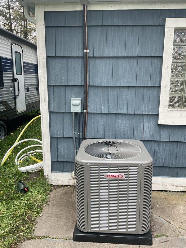 Completed full HVAC system installation including a Lennox 70,000 BTU furnace and 2.5-ton air conditioning unit with rear discharge configuration. The furnace was mounted on a wooden platform in the utility room with proper ductwork connections, PVC condensate drainage, and electrical supply established. The outdoor AC condenser was positioned on a concrete pad against the exterior wall with refrigerant lines run vertically along the siding and secured with mounting brackets. All mechanical and electrical permits were obtained prior to installation, and the system was reconnected and commissioned to manufacturer specifications.