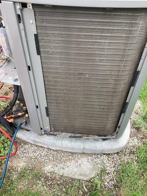 Performed scheduled maintenance on a five-year-old central air conditioning system. Upon arrival, conducted thorough inspection of outdoor condenser unit and found significant accumulation of dirt, dust, and debris on finned coil assembly, which was restricting airflow and reducing cooling efficiency. Cleaned condenser coils to restore proper airflow through the fins. Inspected refrigerant lines, electrical connections, and mounting hardware, all found to be in satisfactory condition. System tested and confirmed operational with proper cooling performance restored following maintenance procedures.