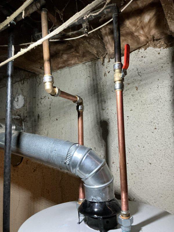 Successfully installed a 50-gallon Bradford White automatic storage water heater in the basement utility area. Completed all plumbing connections using copper piping with brass fittings, including installation of a red-handled ball valve for shutoff control. All connections were properly secured and tested for leaks to ensure safe operation.