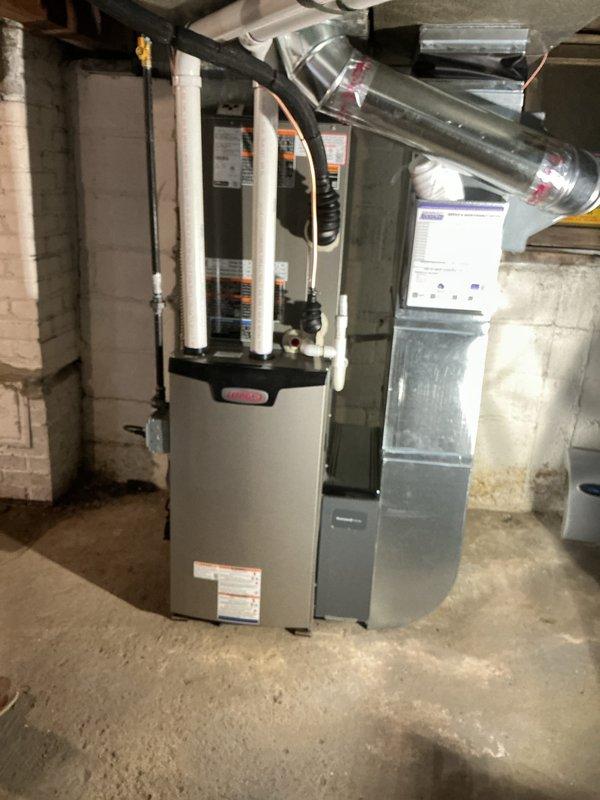 Completed full HVAC system installation including a 70,000 BTU Lennox furnace, 2.5-ton air conditioning unit with rear placement, 40-gallon water heater, and AprilAire humidifier. Installed new electrical circuit for system operation, connected metallic ductwork distribution system, and ran PVC condensate drainage lines. All mechanical and electrical permits obtained prior to installation, equipment mounted and secured in basement mechanical room, and system commissioned for operation.