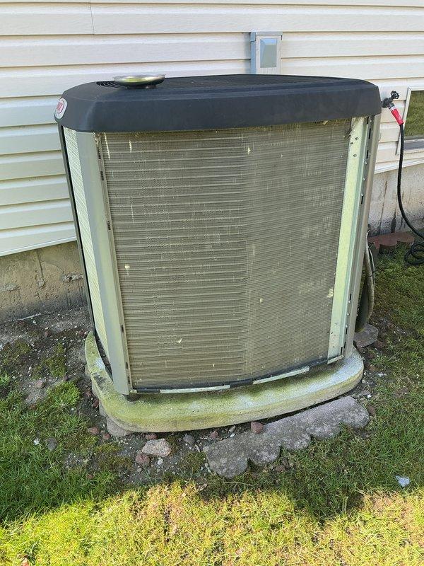 Completed annual cooling maintenance on outdoor condensing unit. Performed comprehensive system inspection, checked refrigerant lines and electrical connections, cleaned condenser coils, and verified proper operation of all components. Unit showed signs of age with algae growth on base and exterior panels but functioned within normal parameters upon completion of service.