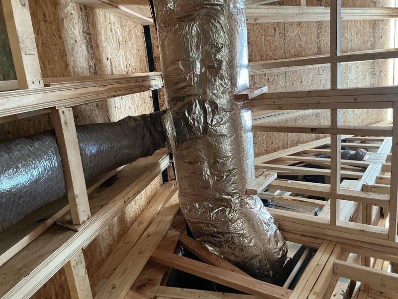 Responded to callback for HVAC installation inspection where disconnected ductwork was found hanging in chase area. Reconnected and properly secured flexible ductwork to framing members, then installed missing fire stop material around duct penetrations through floor joists to meet code requirements. Documented all corrections with photos showing insulated vertical duct run properly supported and fire-rated sealing in place.