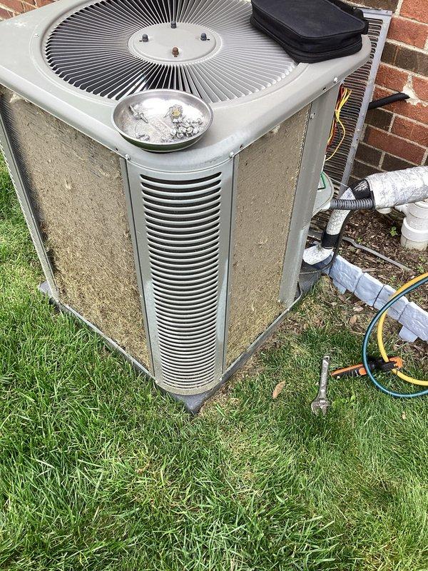 Performed scheduled air conditioning maintenance on outdoor condenser unit. Inspected refrigerant lines, verified service port caps were secure, checked electrical connections, and examined fan assembly and coil condition. Unit operational with no deficiencies noted at time of service.
