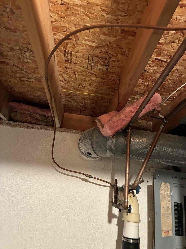 Completed comprehensive whole home plumbing inspection for new homeowner following up on previous inspector's findings. Addressed gas leak at water heater by inspecting connections and gas supply lines, identifying source of leak and performing necessary repairs to ensure safe operation. Installed dedicated shut-off valve on gas line near dryer location to provide proper isolation capability for the appliance. Replaced existing rigid copper gas piping to dryer with code-compliant corrugated stainless steel tubing (CSST), ensuring proper flexibility and safety standards for gas appliance connection. Verified all gas connections for leaks using approved testing methods, confirmed proper operation of water heater and gas supply system throughout home, and documented conditions with photographic evidence of work areas including attic space gas lines and basement water heater installation.
