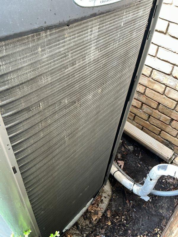 Performed annual cooling maintenance on residential air conditioning system. Inspected outdoor condensing unit and found moderate accumulation of dirt and debris on condenser coil fins, which can restrict airflow and reduce system efficiency. Documented existing condition with photos showing dust buildup on coil surfaces and environmental debris around unit base. Observed weathering on unit exterior casing and condensate drain line. All major components operational at time of inspection. System started and running as expected following maintenance procedures.