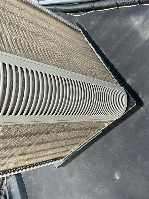 # HVAC Maintenance - ACM Completed

Performed scheduled preventive maintenance on rooftop air conditioning unit as part of recurring Air Care Cooling service agreement. Inspected and documented condition of air filtration system, including two large corrugated air filters housed in metal frames. Filters showed moderate dust accumulation consistent with normal operation. Examined ventilation components including white louvered vent covers with vertical slats and associated ductwork. Verified proper installation and security of insulated refrigerant lines and flexible duct connections with cable ties. Assessed overall system condition, noting typical operational wear on filter media and rooftop mounting surfaces. All HVAC components inspected and photographed for service records. System operational and ready for continued service.