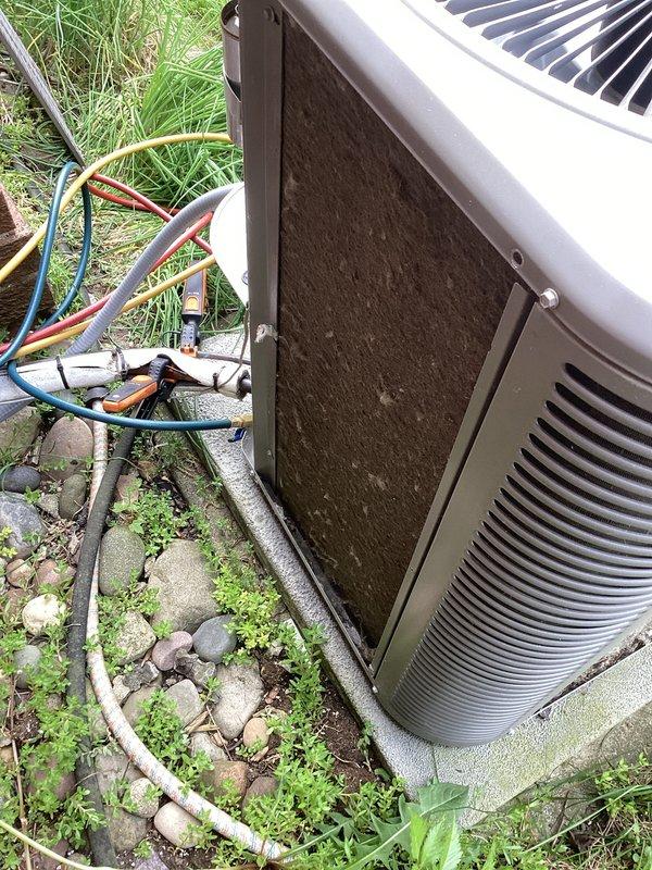 Completed annual cooling maintenance on residential air conditioning system. Performed comprehensive inspection of outdoor condenser unit, which showed significant dirt and debris accumulation on exterior panels and coils. Cleaned condenser coils and exterior surfaces to restore proper airflow and heat transfer efficiency. Inspected electrical connections and wiring. Noted unit requires replacement pads for optimal operation. Documented equipment condition with photos showing before service state with heavy contamination and overgrown vegetation around unit perimeter.