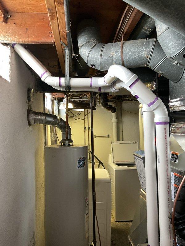 Completed full HVAC system installation including 70,000 BTU furnace with integrated humidifier, 2-ton air conditioning unit with rear discharge configuration, and new ductwork liner. Installed white PVC condensate drainage lines with proper pitch and connections, reconnected electrical service, and verified all system components for proper operation. Permits were obtained prior to installation, and all work was performed to code specifications in basement mechanical room alongside existing water heater.