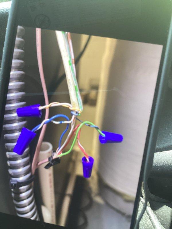Responded to recall for A/C system not turning on or cooling, along with ongoing furnace heating issues where unit stops running before reaching setpoint. Inspected thermostat wiring and control panel connections, verifying proper wire terminations at RC, RH, O/B, Y, G, W/E, and C terminals. Examined wire connections within HVAC equipment control panel, checking all wire nuts and electrical connections for secure contact. Documented wiring configuration and thermostat interface to ensure proper communication between components and resolve intermittent operation issues affecting both cooling and heating functions.