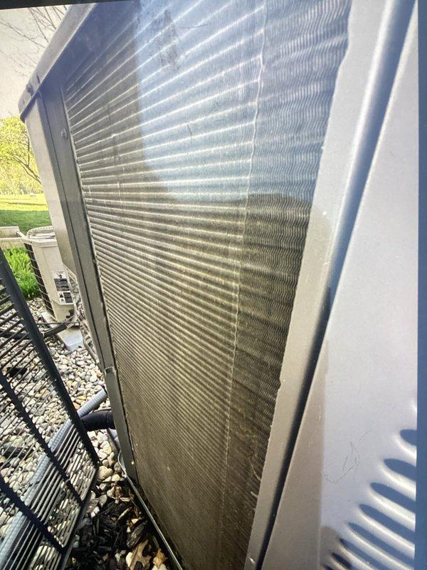 Completed scheduled Air Care Maintenance on residential HVAC system. Inspected condenser coil and heat exchanger assembly, noting moderate dust and environmental debris accumulation on exterior fins with visible discoloration on lower sections. Replaced air filter and documented unit condition with photographic evidence showing typical outdoor wear patterns on coil surfaces.
