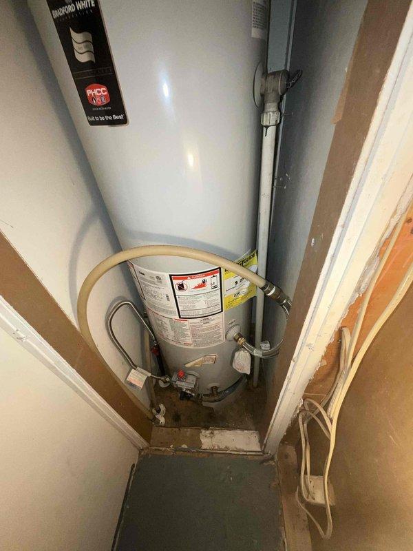 Responded to service call for non-functional Bradford White standard tank water heater. Assessed existing unit installed in utility closet with atmospheric venting system and copper supply lines. Provided estimate for replacement of failed water heater with new standard tank unit, including necessary connections to existing gas line, water supply piping, venting system, and code-compliant installation with required safety devices and shut-off valves.