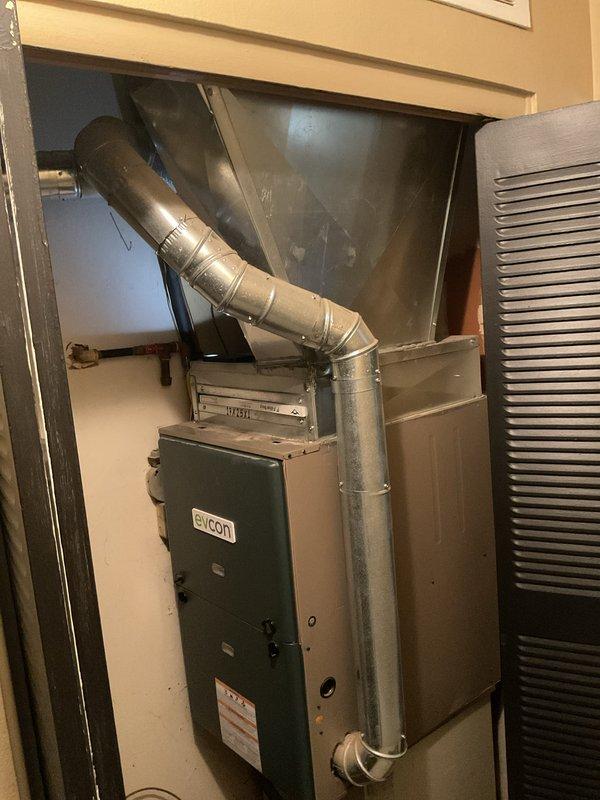 Completed installation of 70,000 BTU Yukon furnace and 2-ton air conditioning system with rear discharge configuration. Installed new ductwork connections in attic space using flexible and rigid metal ducting with proper sealing and support. Unit positioned in utility closet with exhaust venting routed through existing opening, exploring installation method that minimizes chimney modifications per callback assessment.