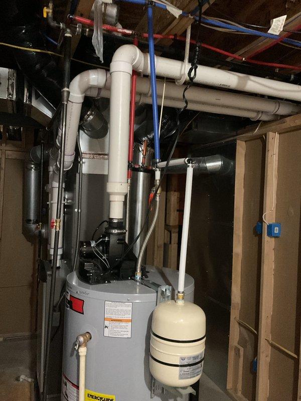 Completed full HVAC system installation including a 135,000 BTU gas furnace and 5-ton air conditioning unit with rear discharge configuration. Obtained mechanical and electrical permits prior to installation. Installed new furnace in mechanical room with proper venting through white PVC exhaust piping routed through exterior brick wall, connected all gas lines, electrical connections, and integrated with existing water heater and utility infrastructure. Mounted outdoor condensing unit, completed refrigerant line connections, and performed all necessary electrical hookups. System tested and verified operational upon completion.